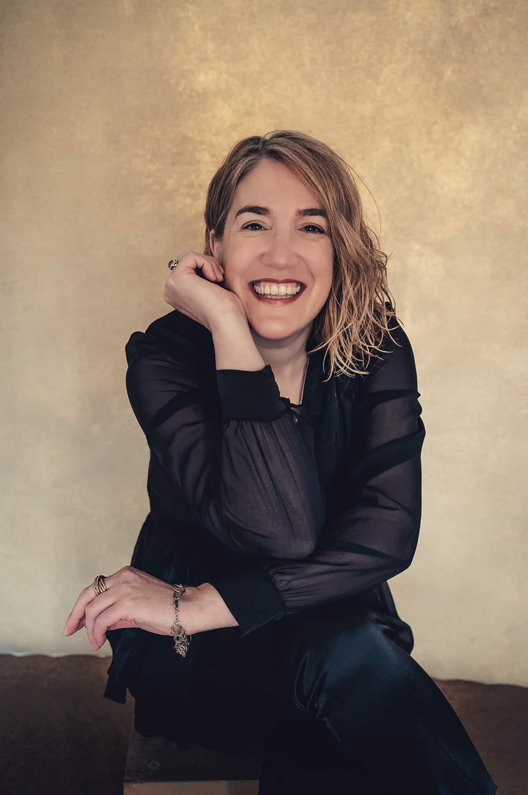 Jules of Gently Created, smiling with her chin resting on her hand.